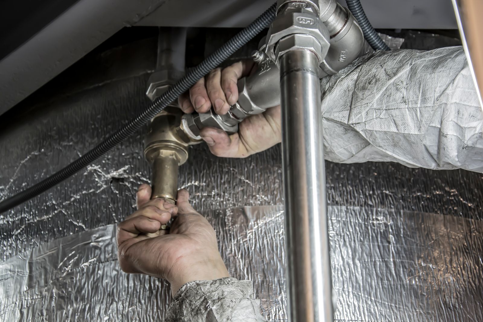 Licensed plumber replacing old polybutylene supply pipe with new piping