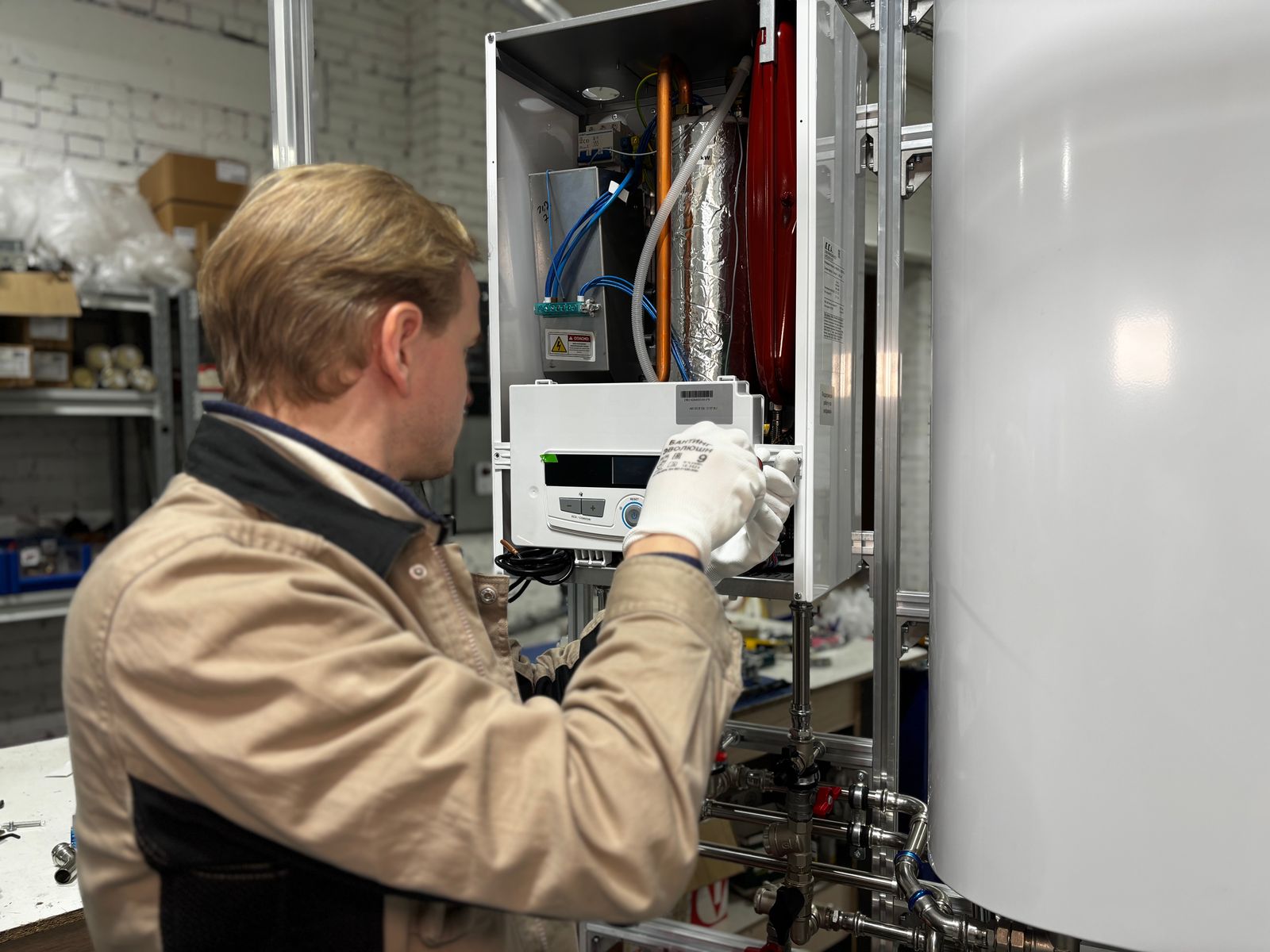 Technician installing a replacement water heater in a home utility room